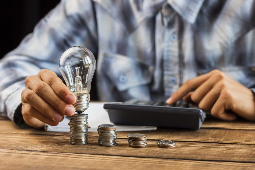 Man counting the stack of coins illustrating increased utility bills
